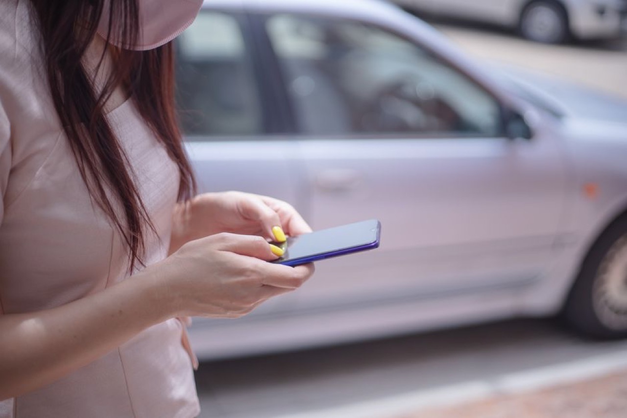 Person on phone next to car