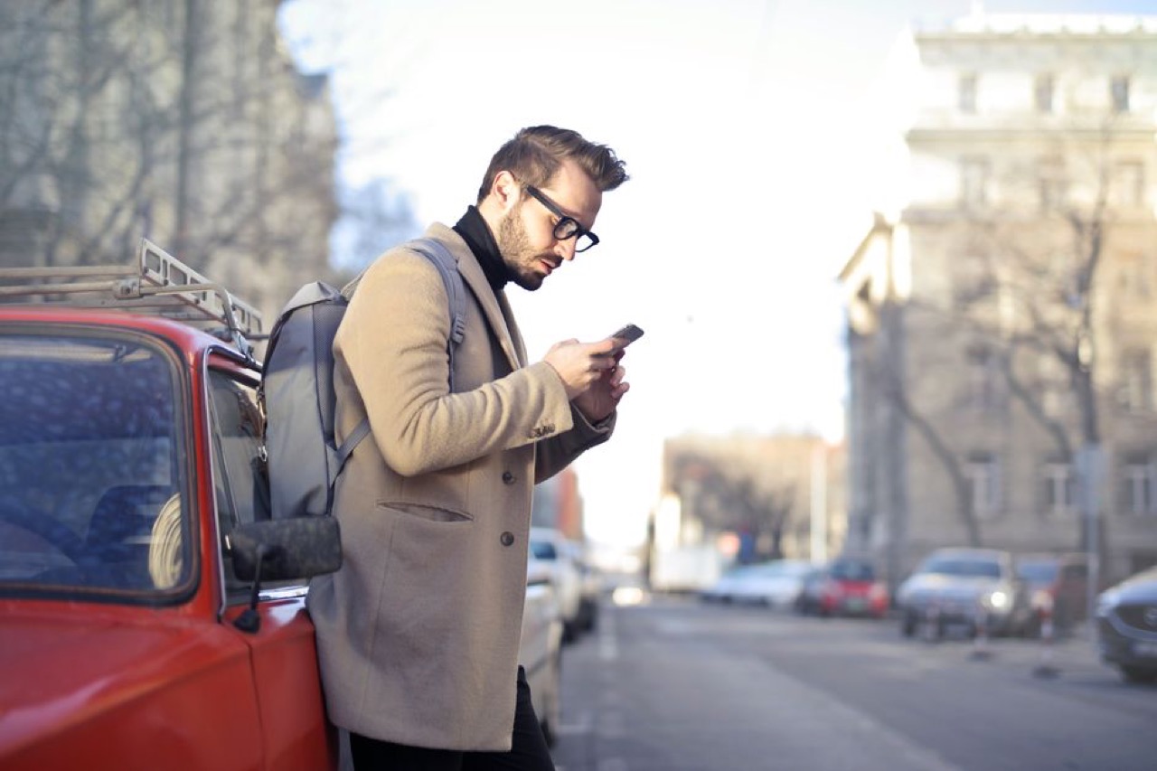 Person on phone next to car
